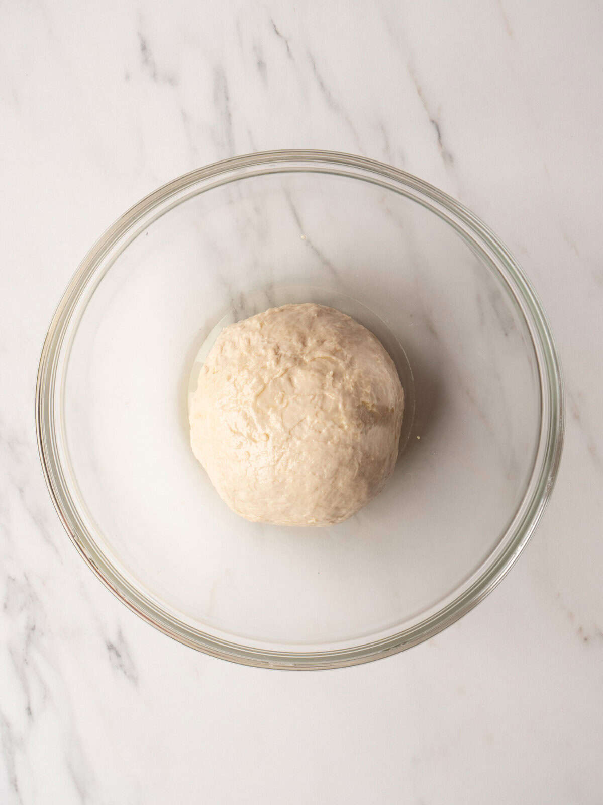 Dough ball in glass bowl.
