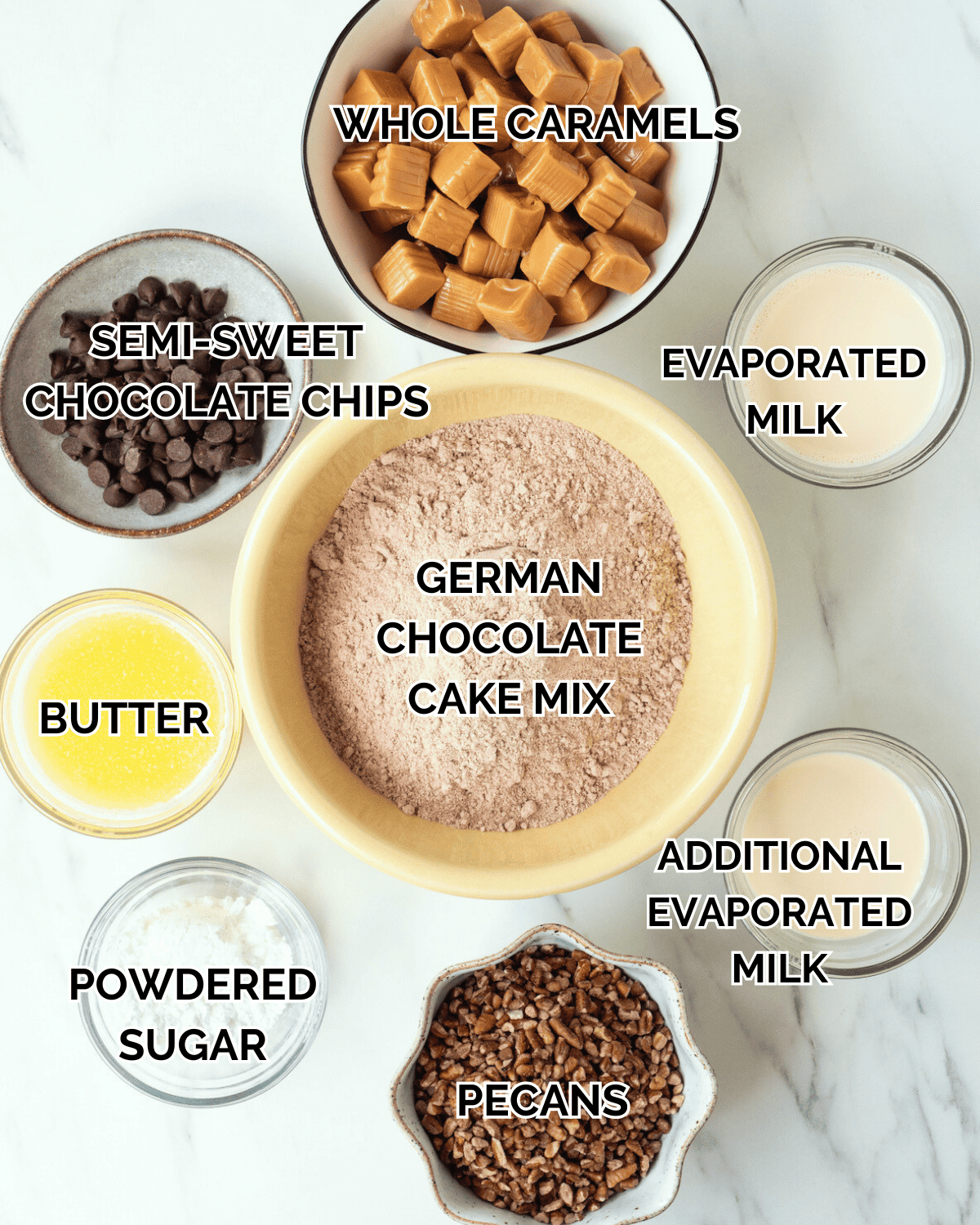 All of the ingredients sit in individual prep bowls.  Ingredients consist of whole caramels, evaporated milk, chocolate chips, melted butter, powdered sugar, pecans, and evaporated milk.