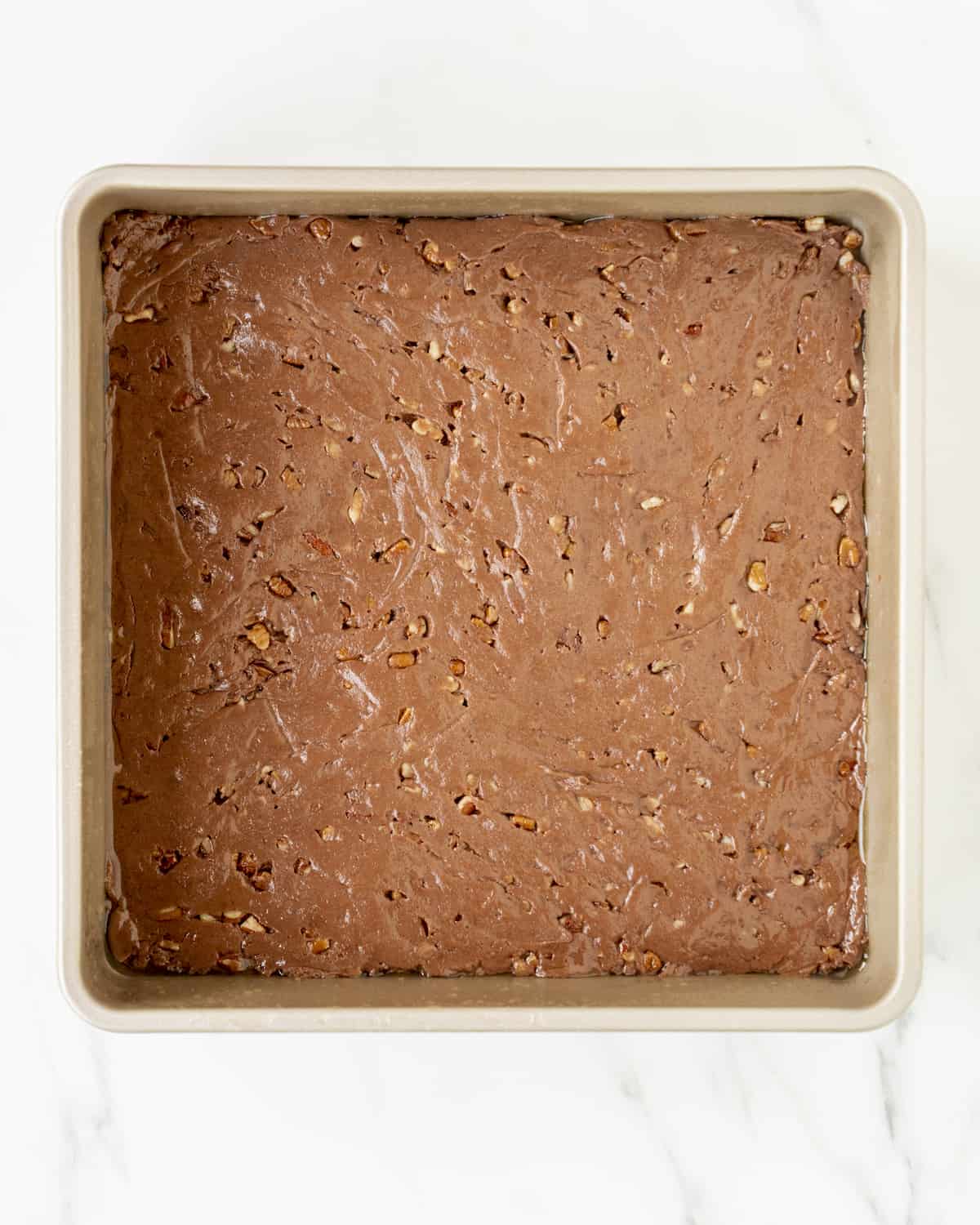 A square baking pan filled with the brownie batter.  