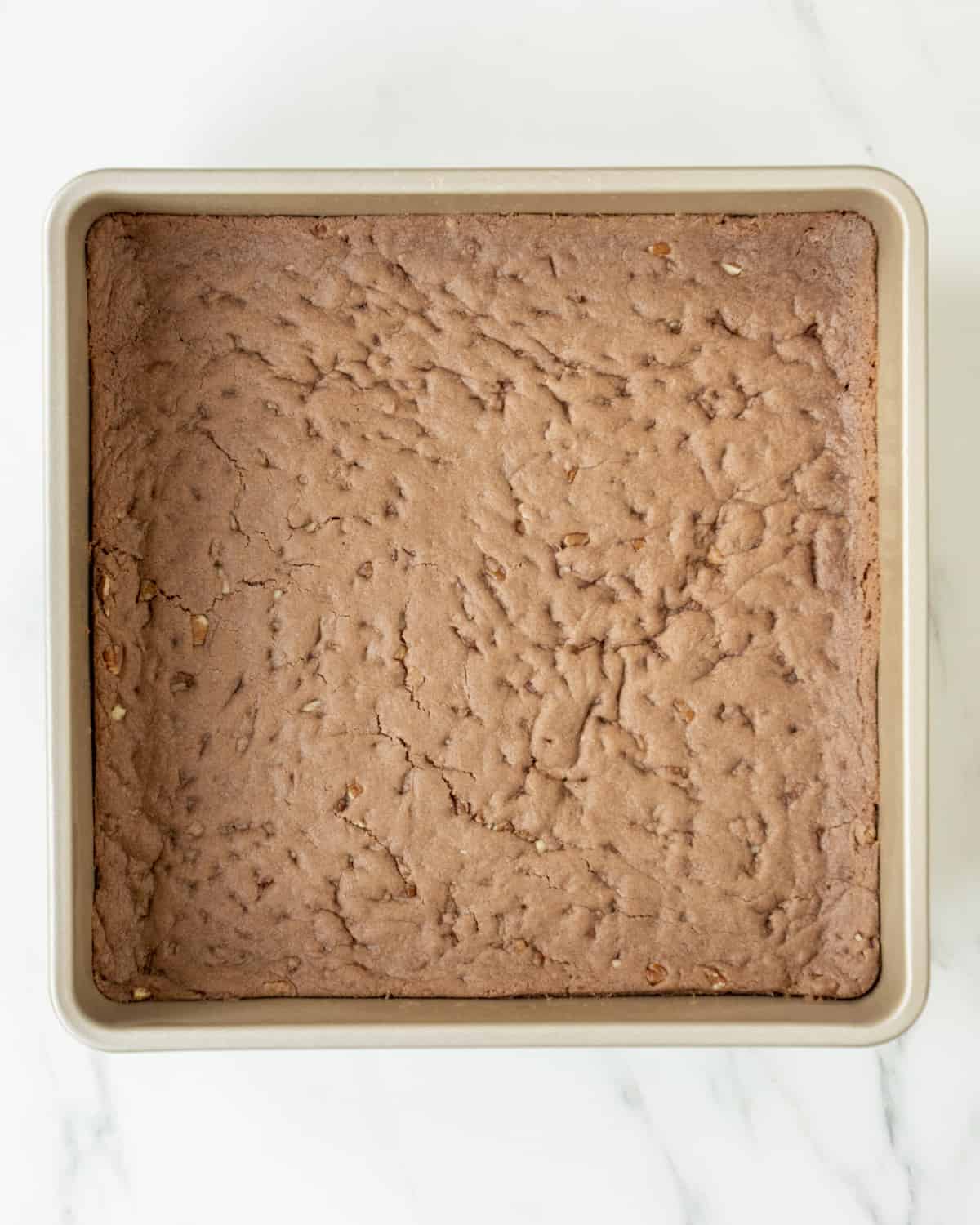 A square baking pan filled with the cooked brownie batter.  