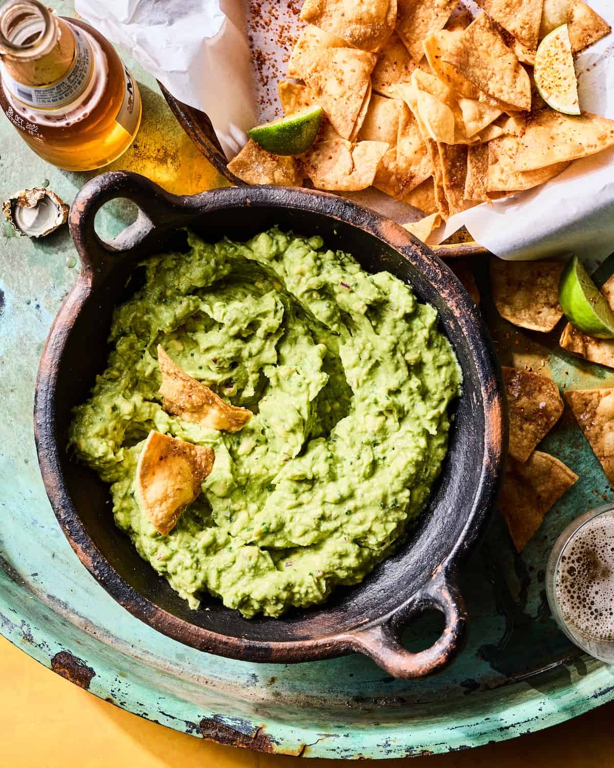 Homemade guacamole with freshly fried tortilla chips on a platter