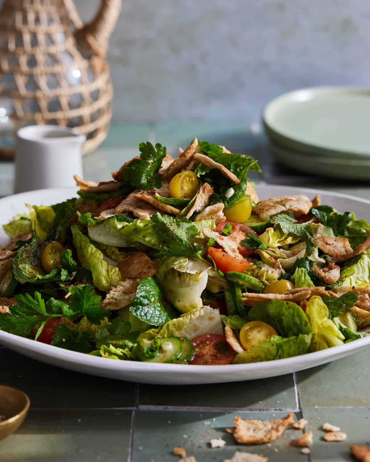 Fattoush Salad in a large serving bowl with plates 