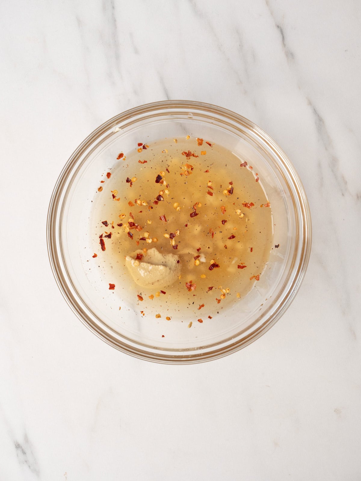 A bowl with all the ingredients to make champagne vinaigrette.