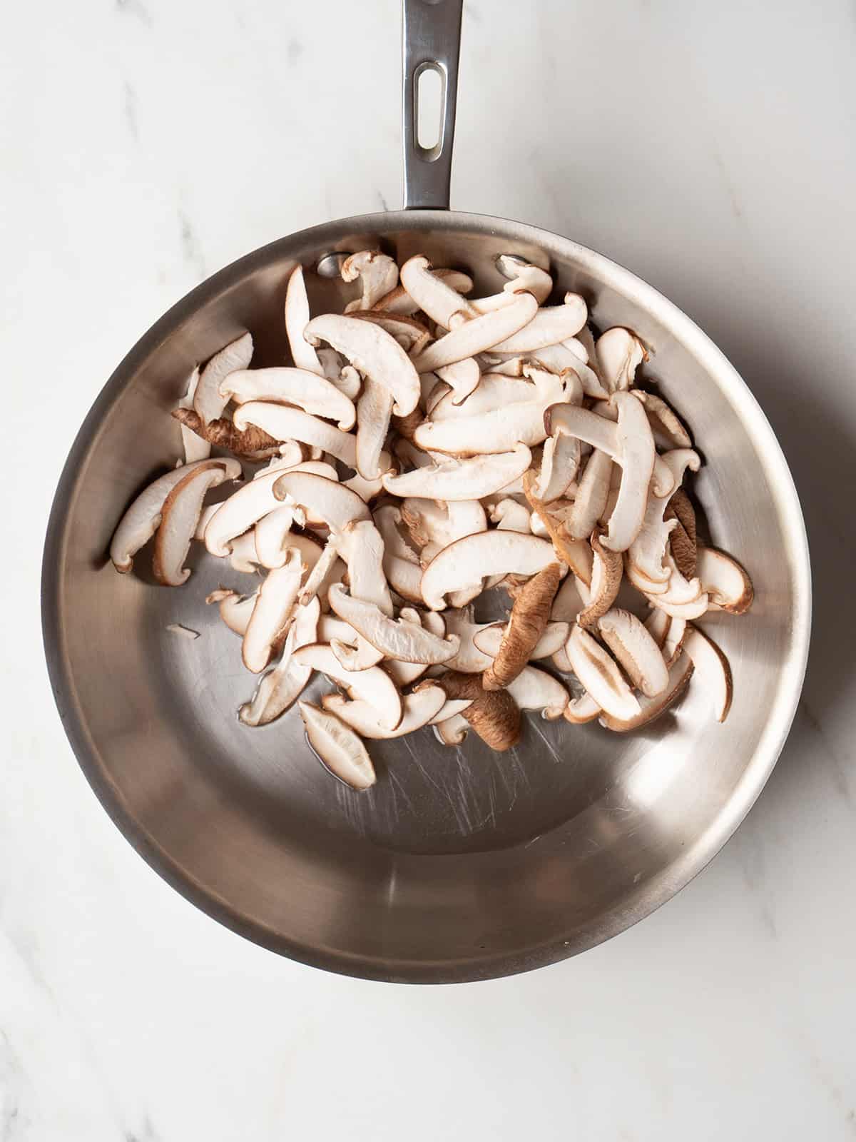 Sliced mushrooms in a metal pan