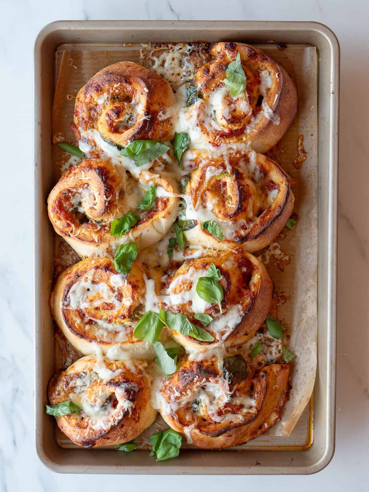 Cheesy pizza rolls with basil garnish