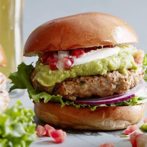 Cheddar Jalapeno Chicken burgers with guacamole, sour cream, pico, sliced red onion, and lettuce