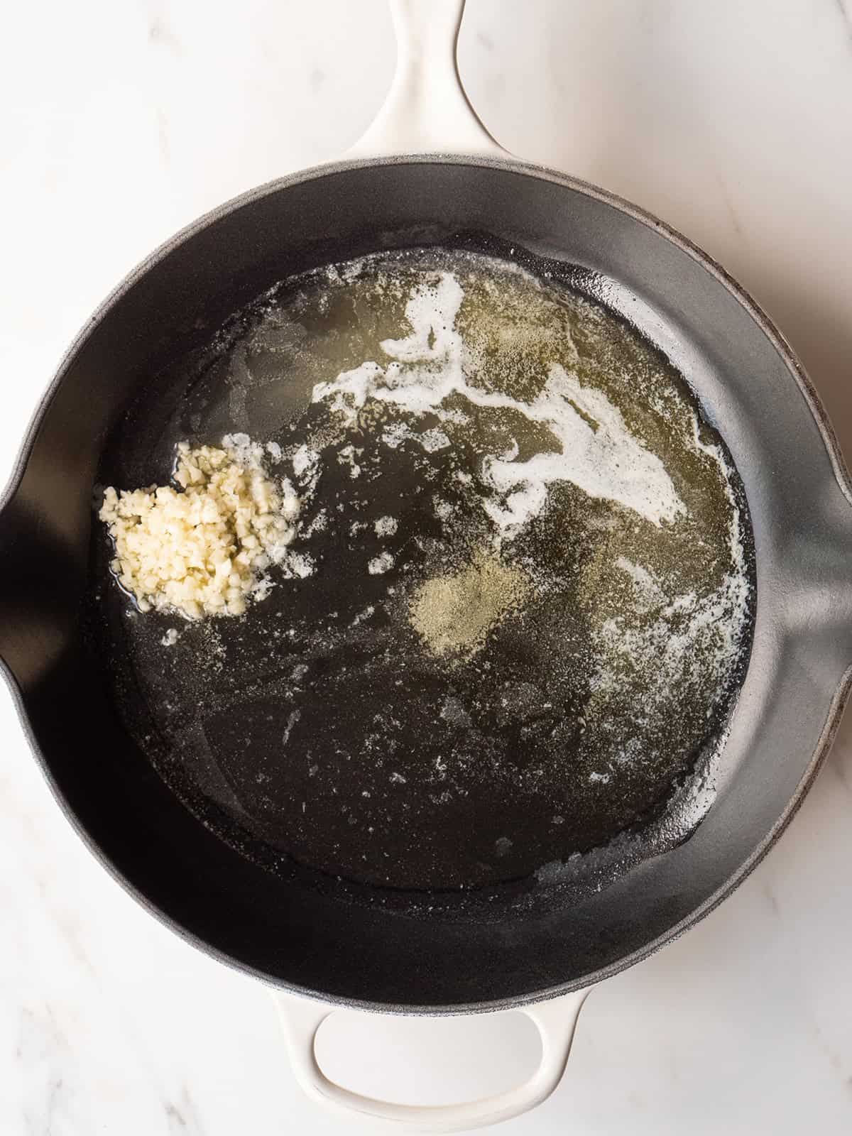 Melted butter and minced garlic in skillet