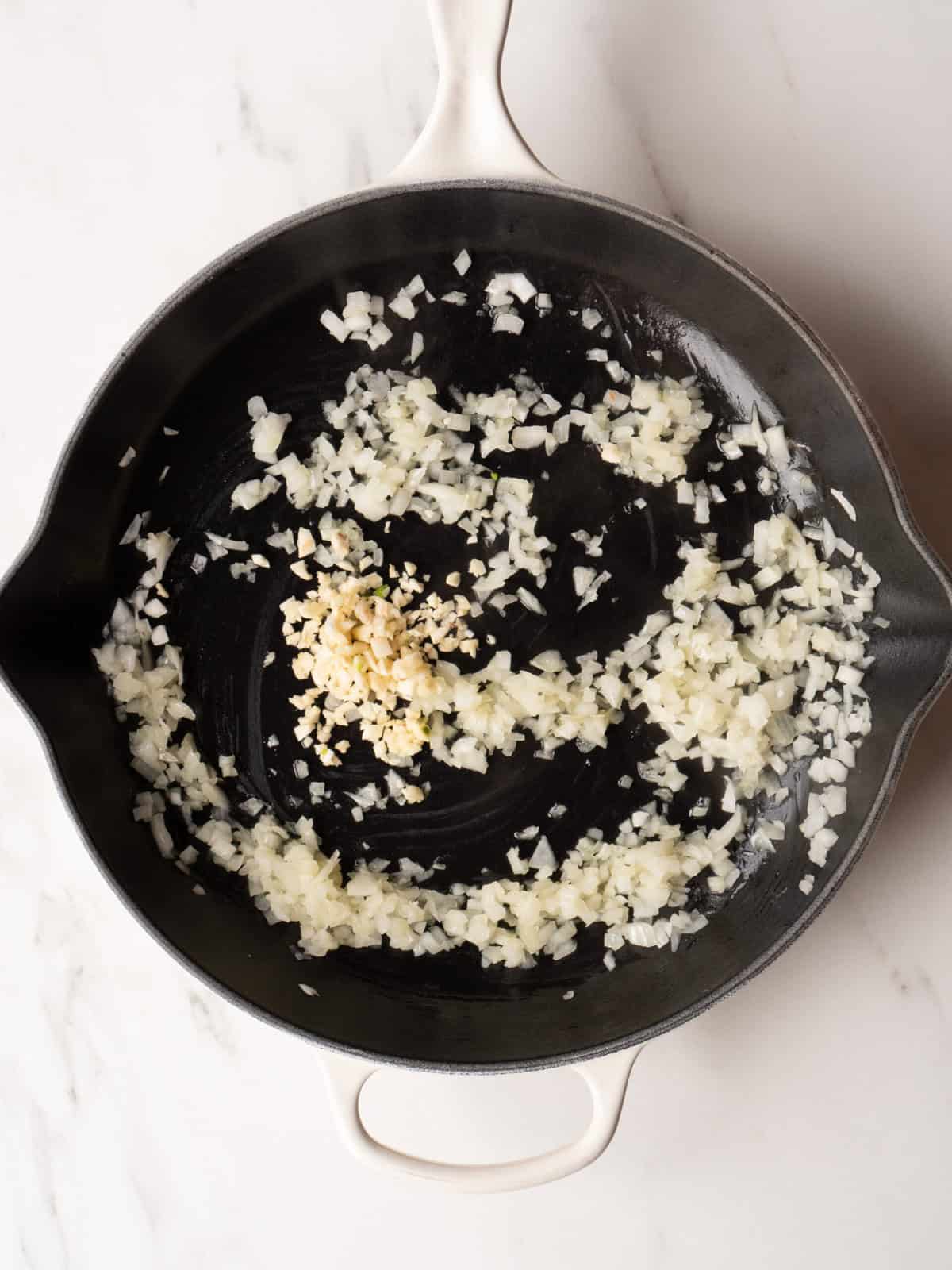 Chopped onions sautéing in skillet