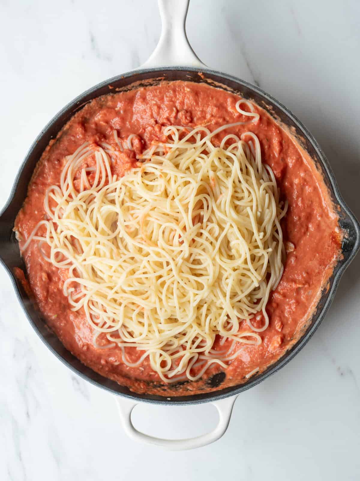 Spaghetti on top of tomato sauce
