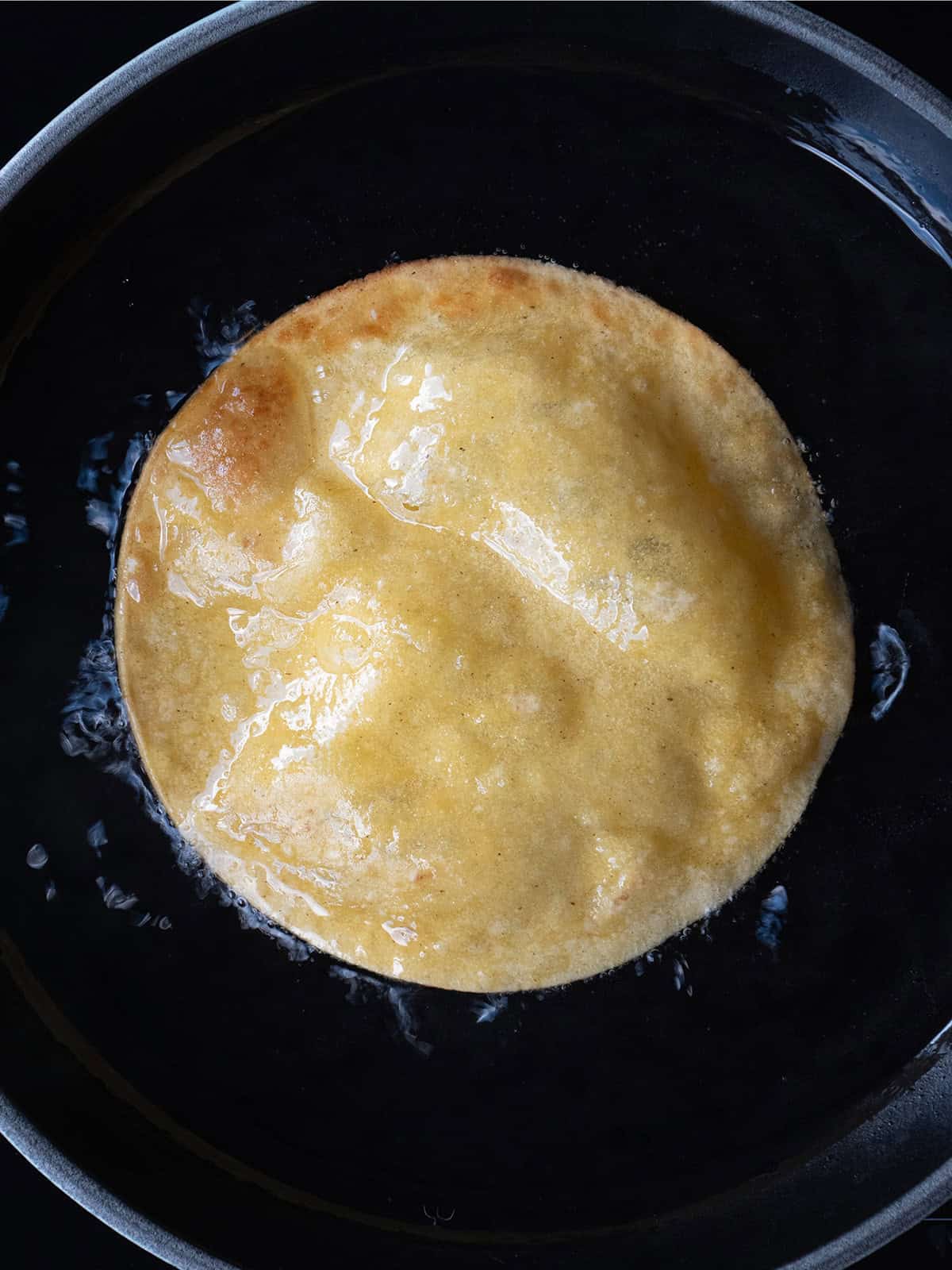 Golden, crispy tortilla in frying pan