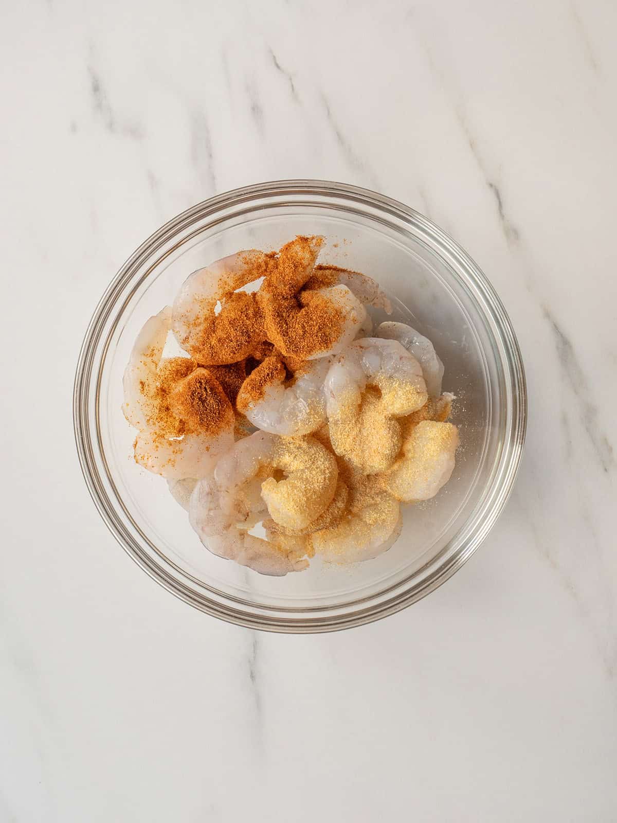 Raw shrimp with seasoning in bowl