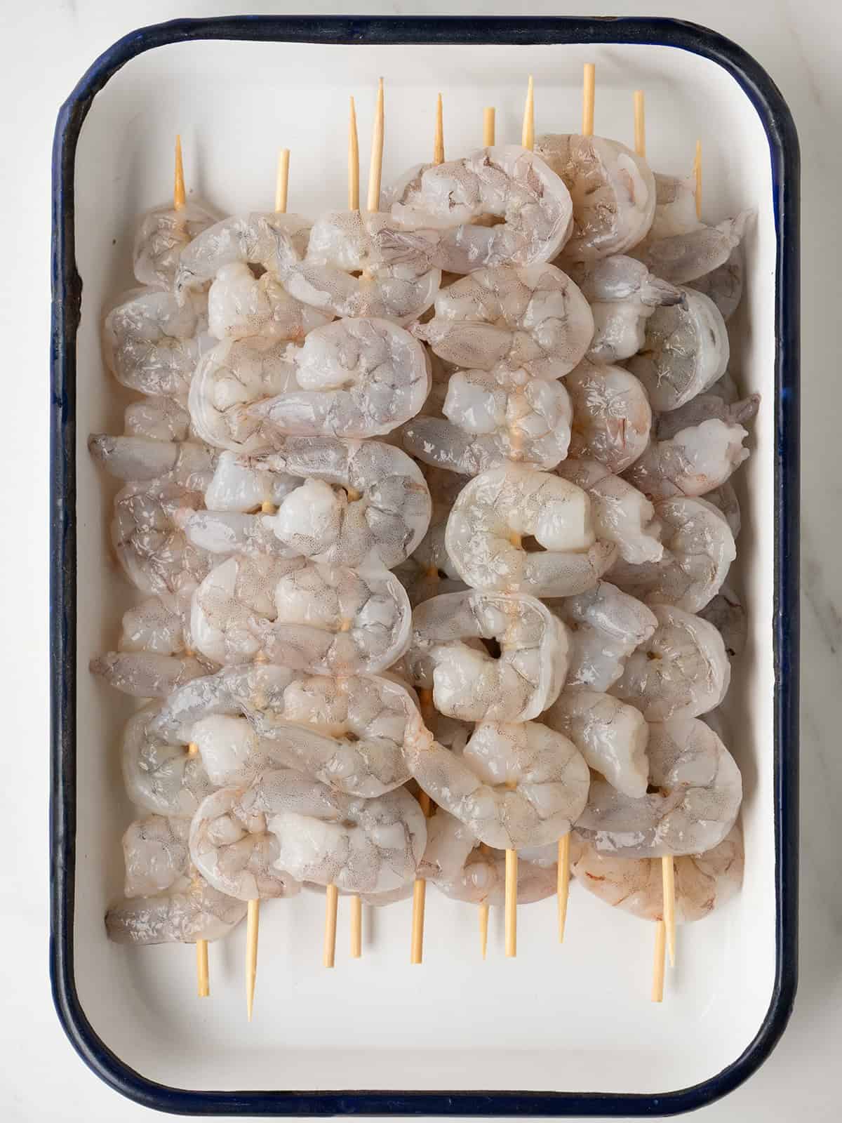 Raw shrimp skewered on wooden sticks