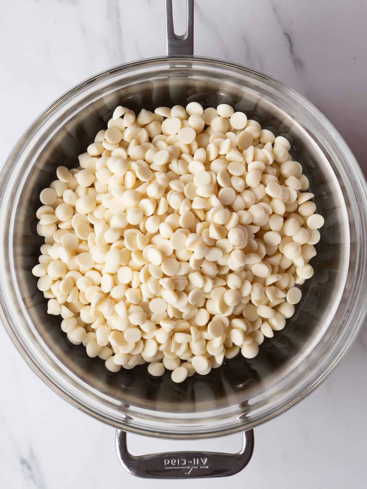 A double boiler with white chocolate in it.