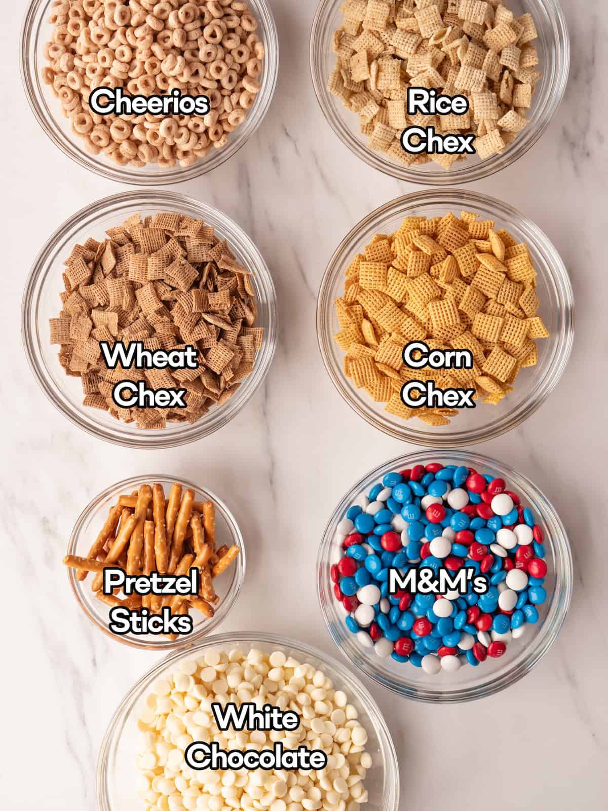 Mise en place of all ingredients to make a 4th of July Chex mix in white chocolate.