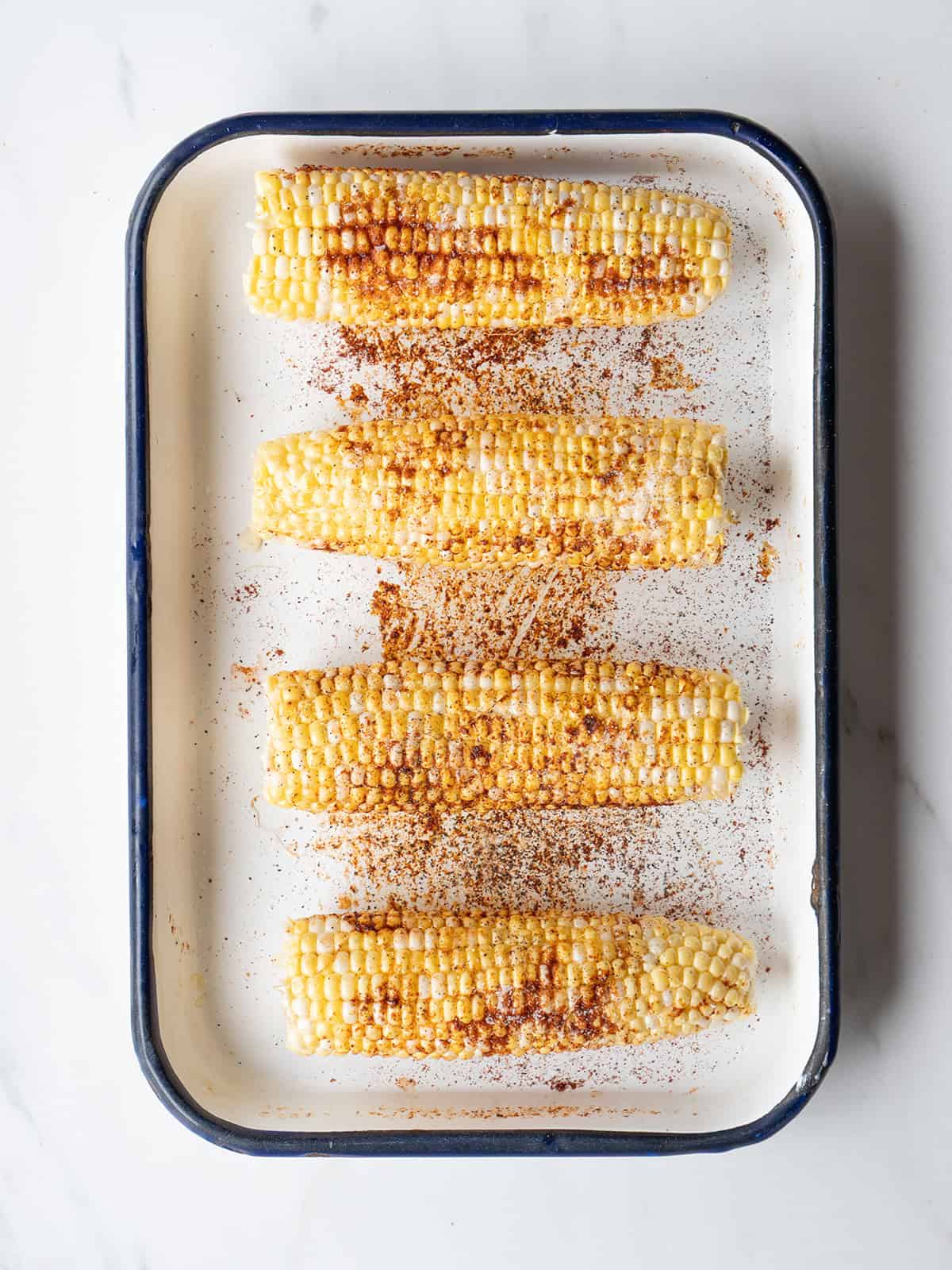 Grilled corn on a white tray