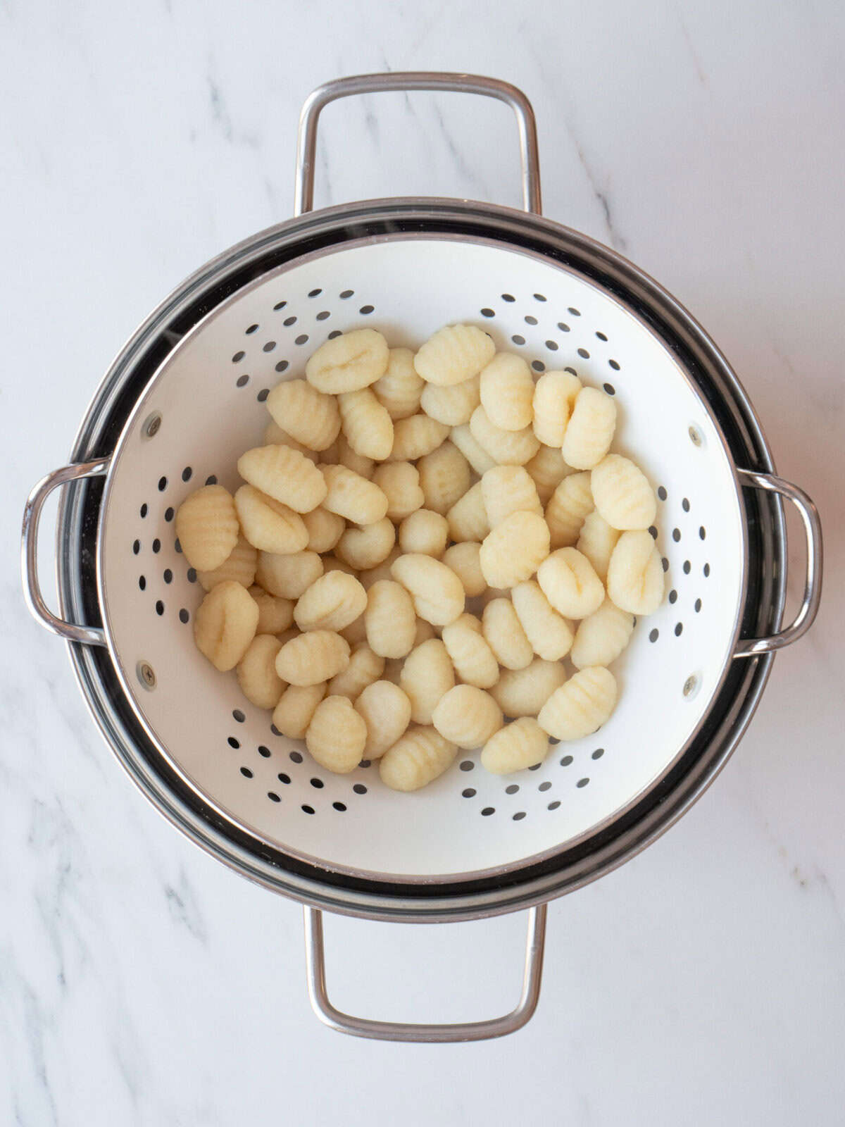 Colander filled with uncooked gnocchi