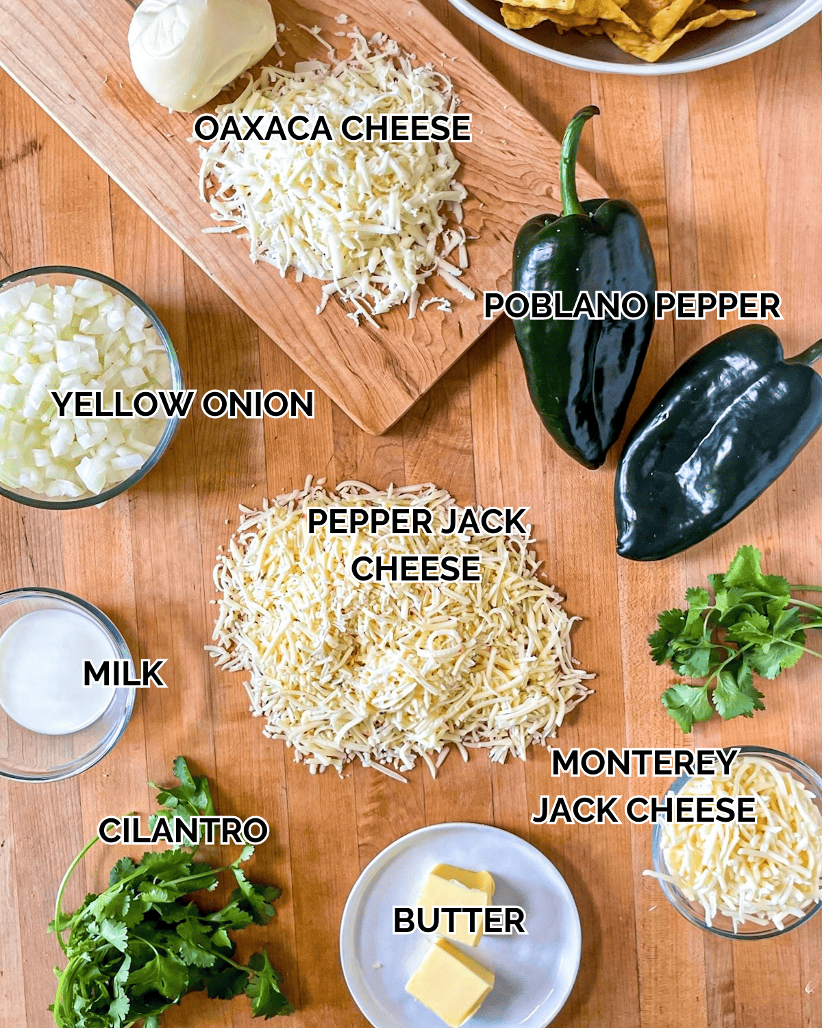 Queso Fundido Ingredients Poblano Peppers, Butter, Yellow Onion, Milk, Shredded Monterey Jack Cheese, Shredded Oaxaca Cheese, Shredded Pepper Jack Cheese, Tortilla Chips, Cilantro