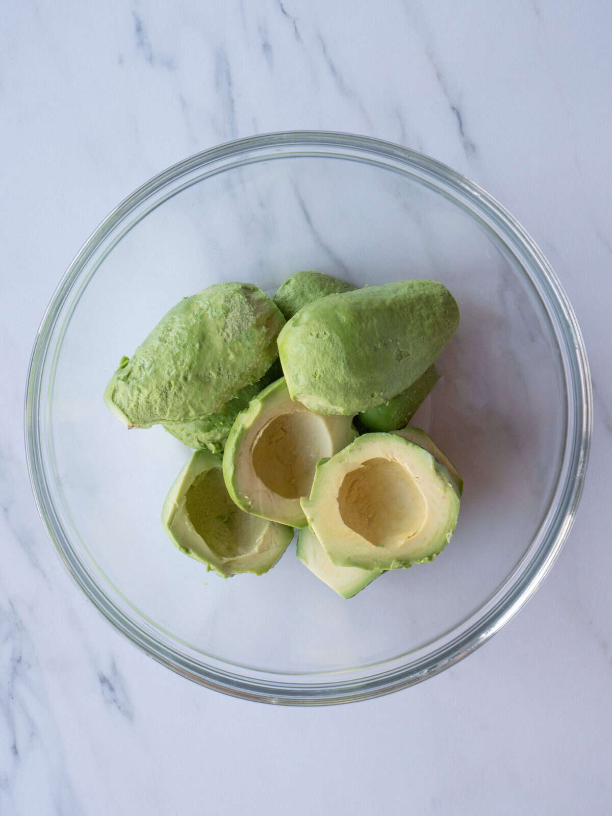 Sliced avocados in a glass bowl