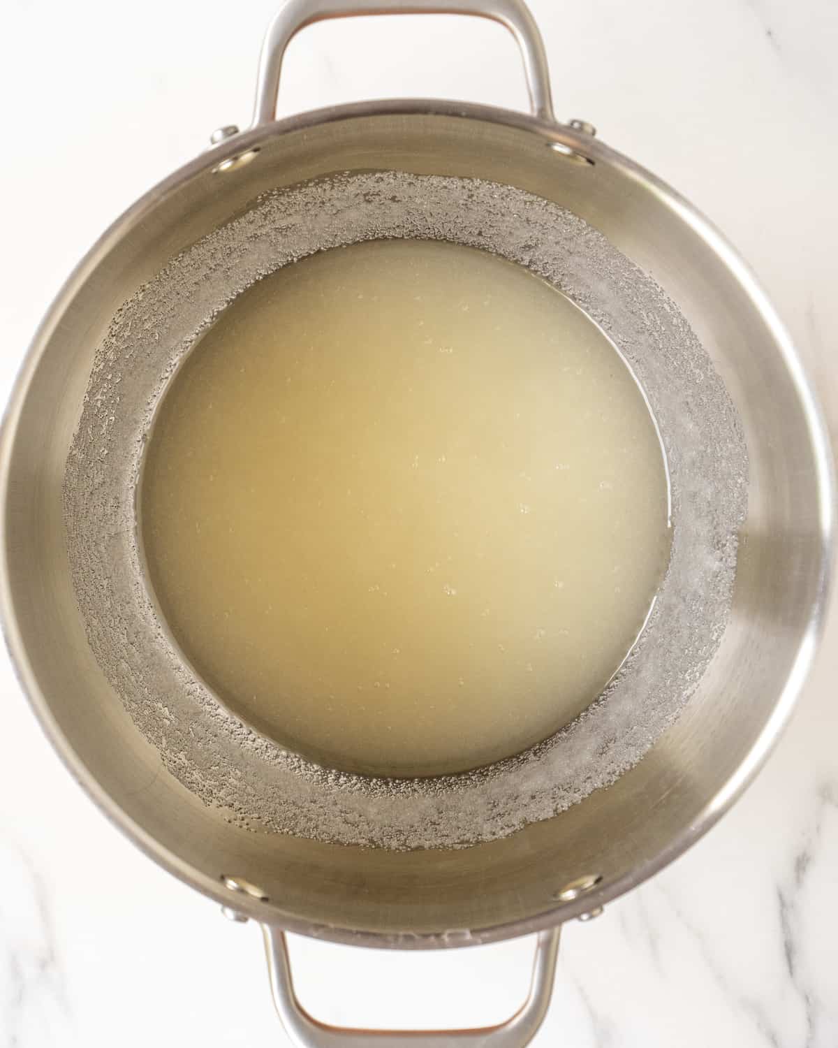 A stand mixer bowl with a mixture of oil and sugar
