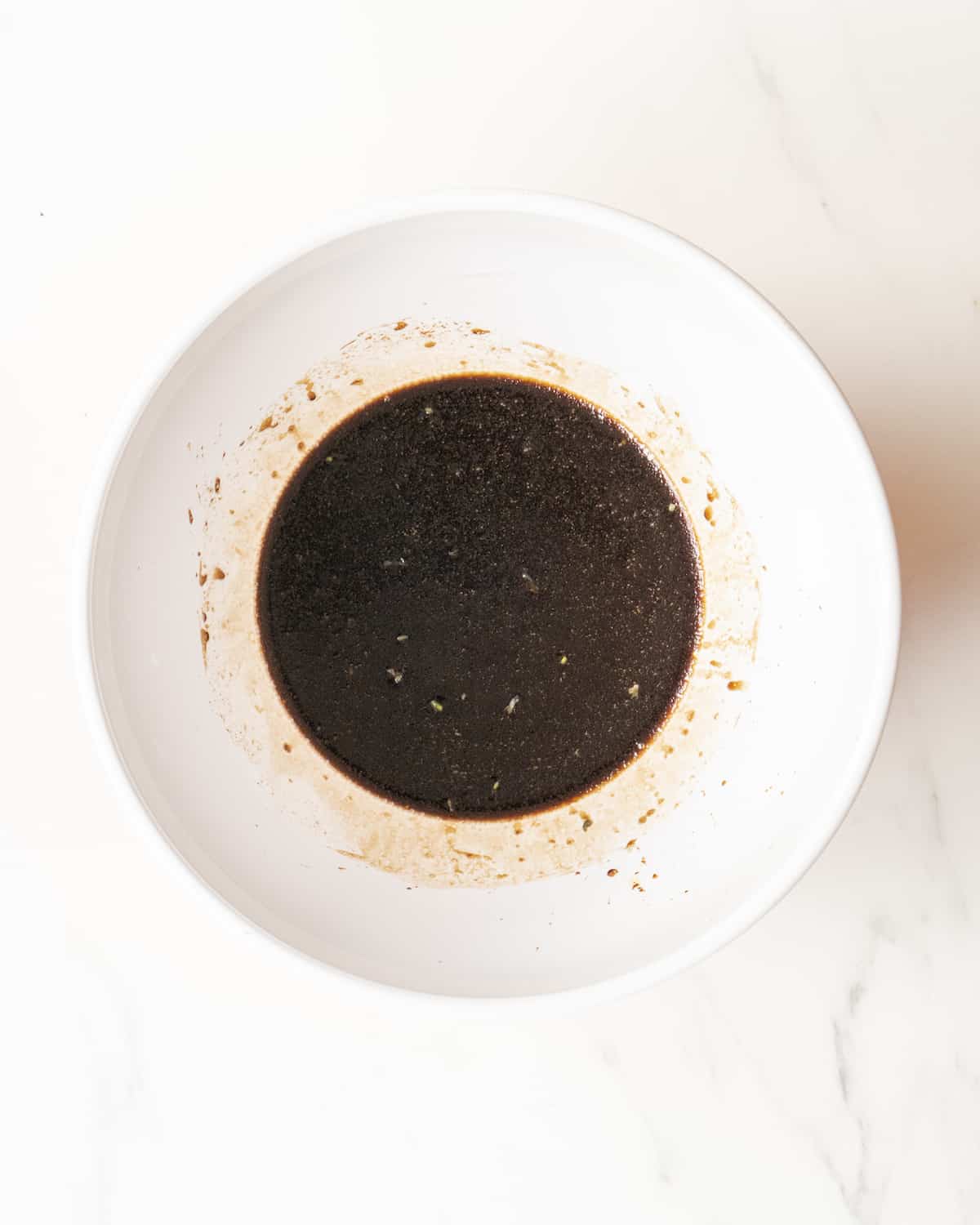 Balsamic dressing in a large white mixing bowl