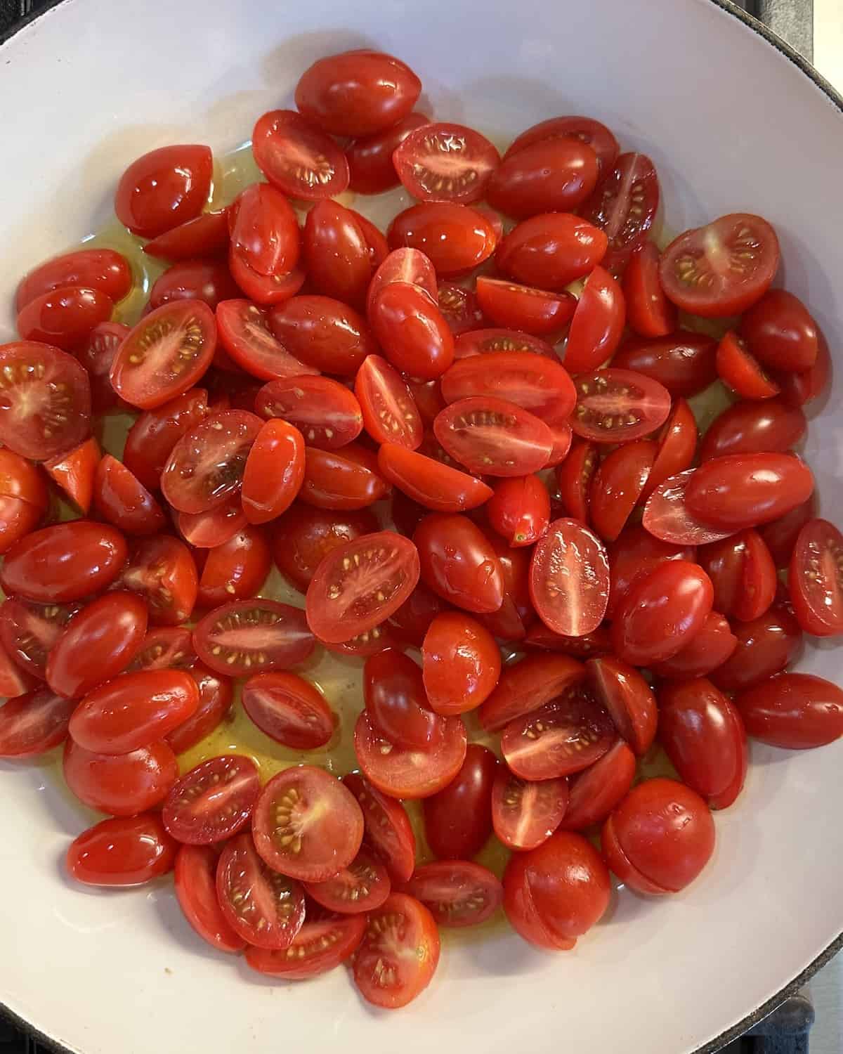 Halved cherry tomatoes in a medium skillet with olive oil over medium high heat.