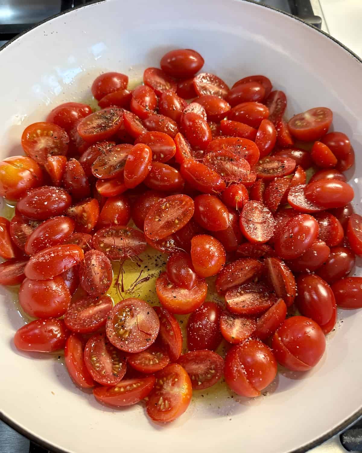 Halved cherry tomatoes in a medium skillet with olive oil saffron salt and pepper over medium high heat.