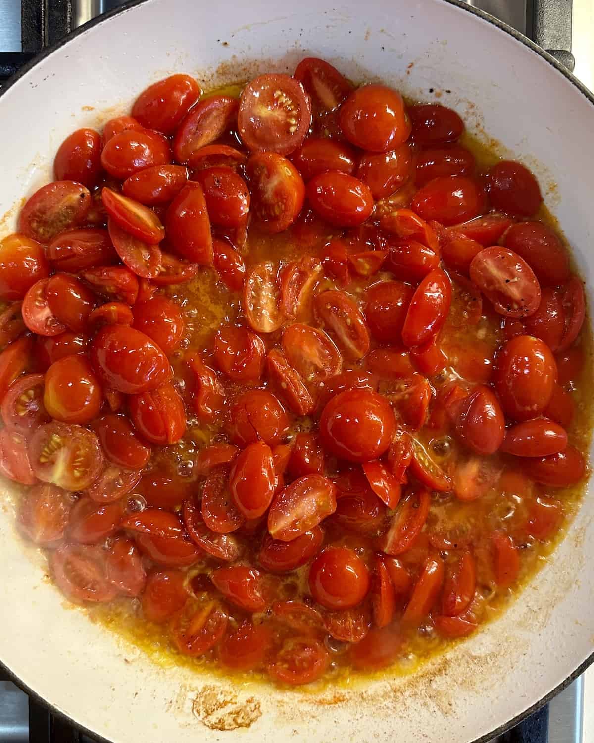 Halved cherry tomatoes in a medium skillet that have started to blister