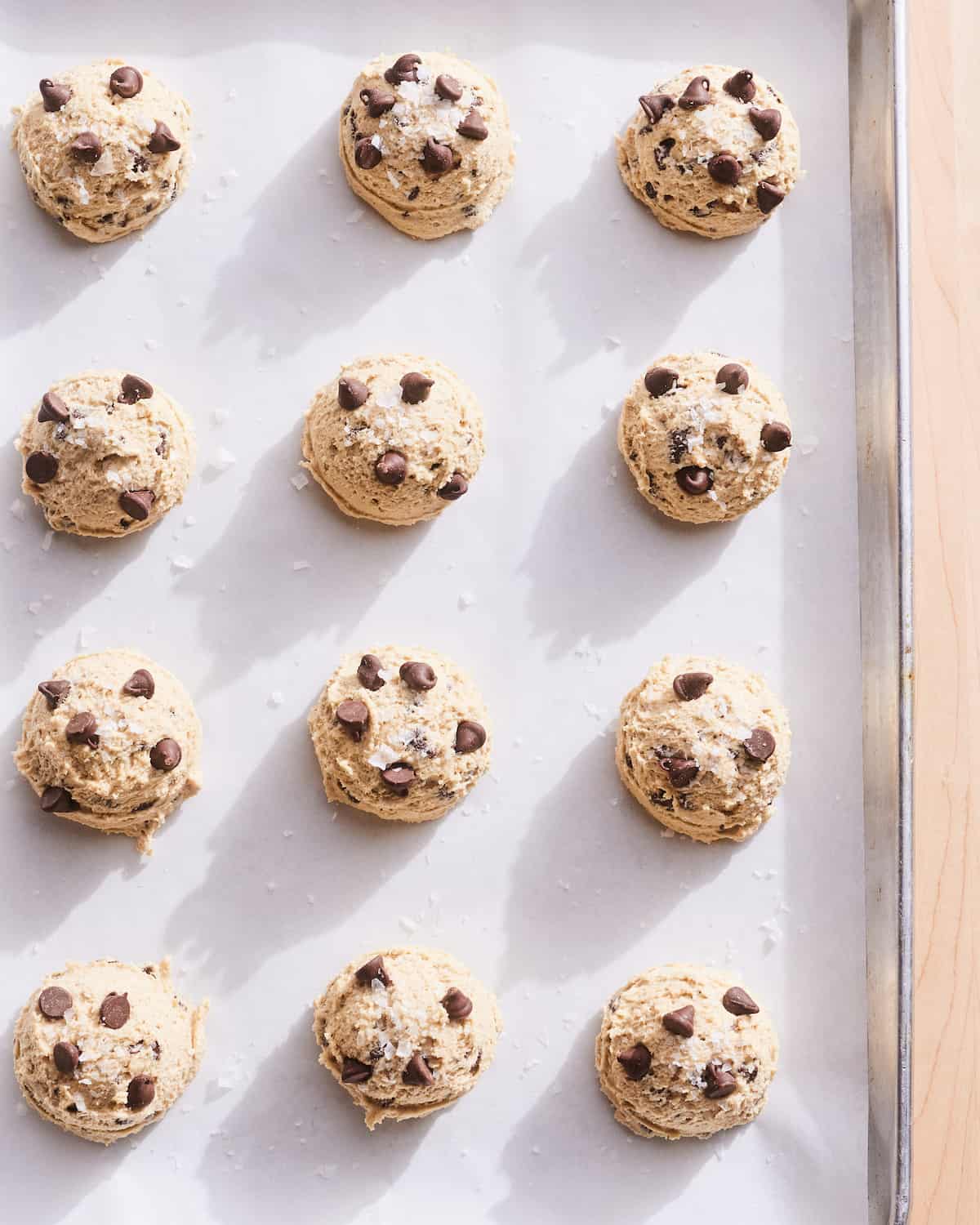 Unbaked Chocolate Chip Cookies on a baking sheet lined with parchment