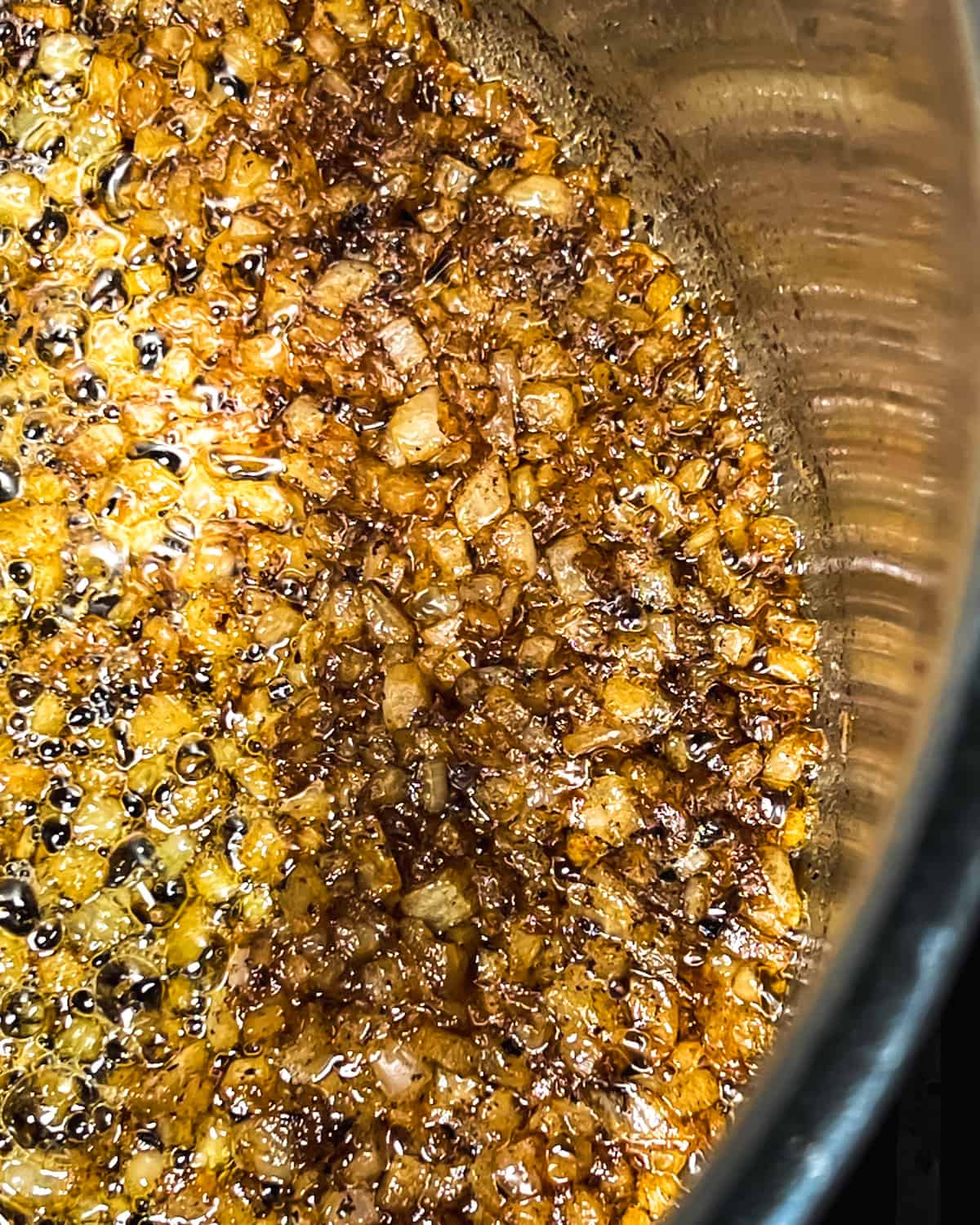 caramelized diced yellow onions in a large metal stock pot