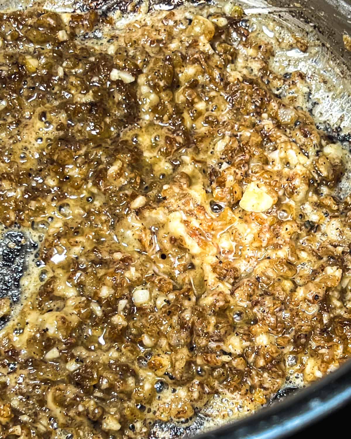 caramelized diced yellow onions in a large metal stock pot with minced garlic and flour that has been stirred until the flour is cooked.