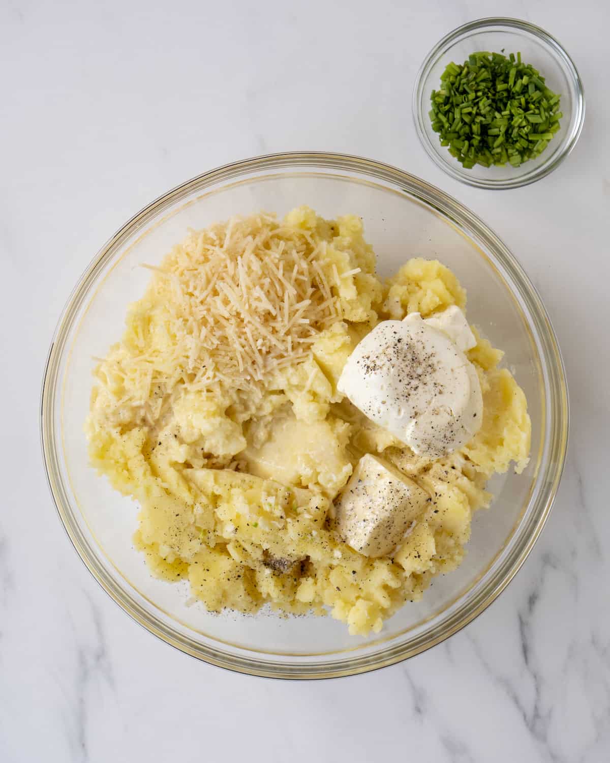 A glass bowl of the mashed potatoes with the marscapone cheese, parmesan cheese, garlic, and butter.  