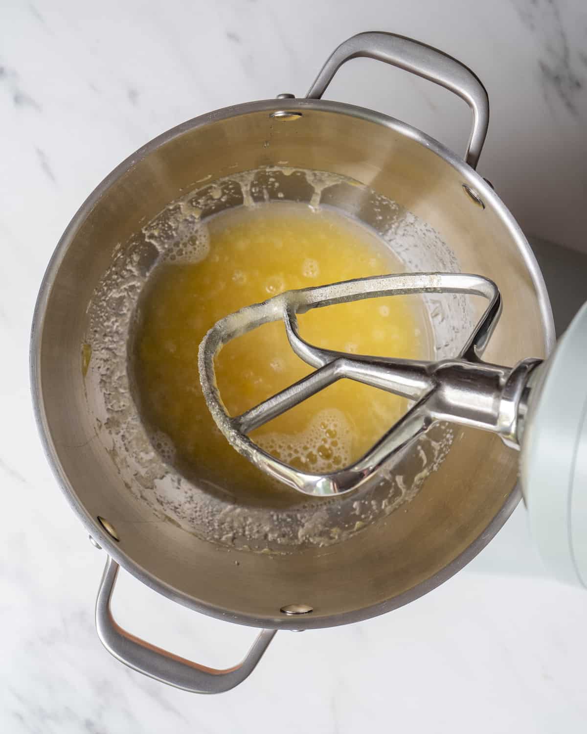 Eggs, sugar, vegetable oil, and vanilla has been mixed together in a stand mixer.  