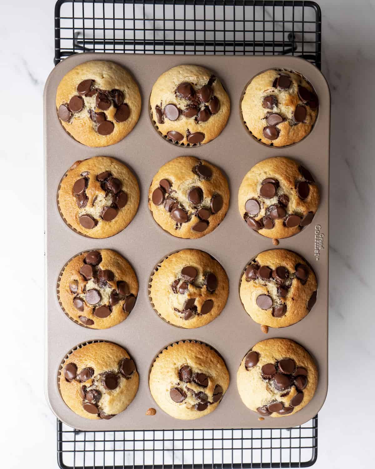 a 3x4 muffin tin filled with cooked chocolate chip muffins.  