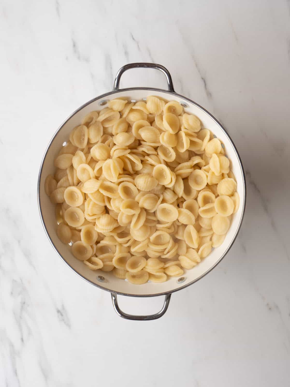 A colander with boiled orecchiette drained.