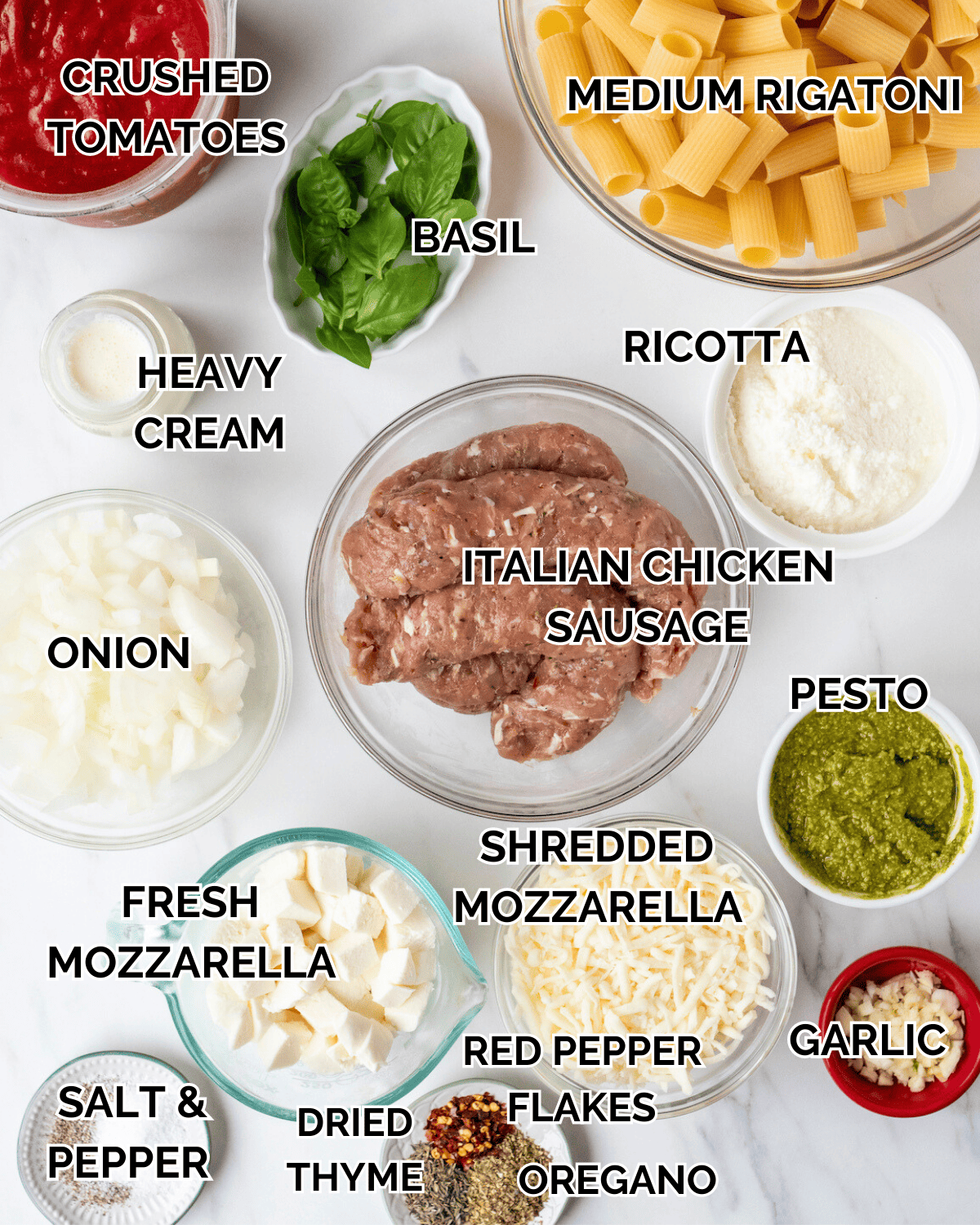 Mise-en-place with all the ingredients required to make baked rigatoni with ground chicken sausage, pesto and ricotta.