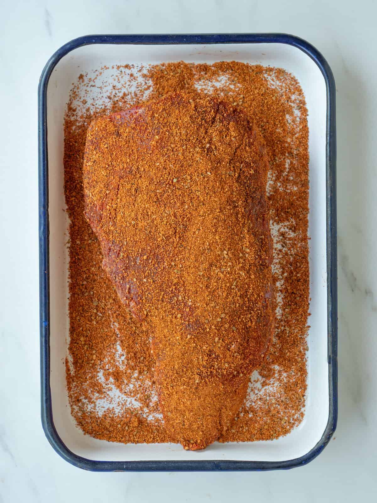 Seasoned meat in a tray