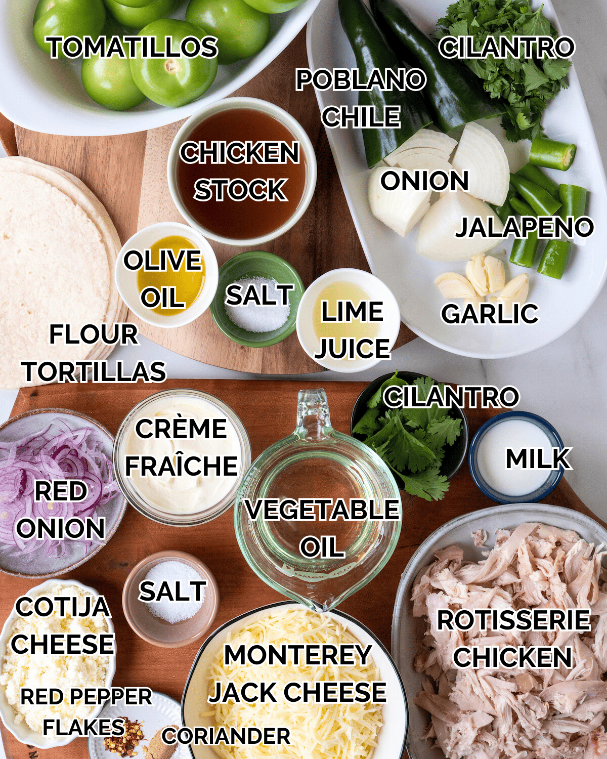 A shot of all the ingredients in this dish sitting in individual vessels. Ingredients include the following: Tomatillos, poblano chile, cilantro, onion, jalapenos, garlic, chicken stock, olive oil, salt, lime juice, flour tortillas, creme fraiche, red onions, vegetable oil, milk, salt, cotija, red pepper flakes, coriander, monterey jack cheese, and rotisserie chicken.