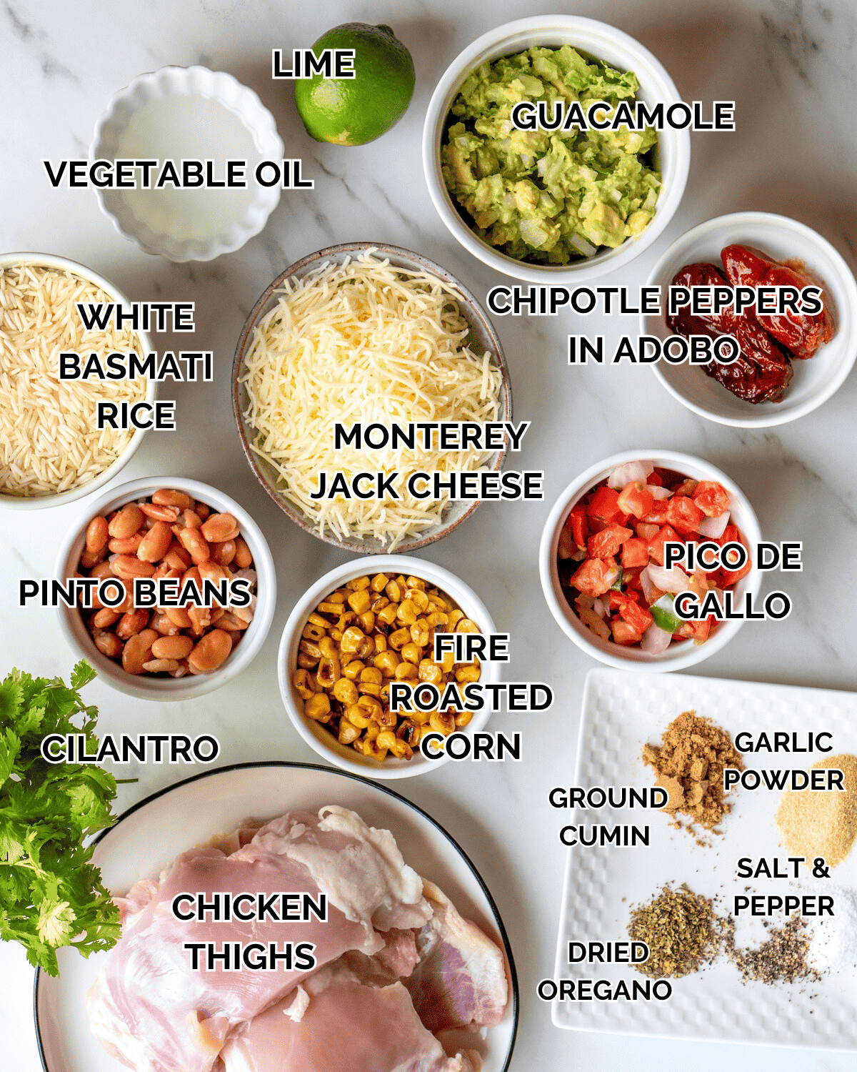 Each of the following ingredients is sitting in an individual prep bowl on a marble countertop.  Vegetable Oil, Chipotle Peppers , Garlic Powder, Boneless Skinless Chicken Thighs, White Basmati Rice, Cilantro, Pinto Beans, Frozen Charred Corn, Guacamole, Pico de Gallo, and Monterey Jack Cheese.  The dry ingredients are sitting on a single plate.  These are the dry ingredients Ground Cumin, Dried Oregano, Black Pepper, and Kosher Salt.