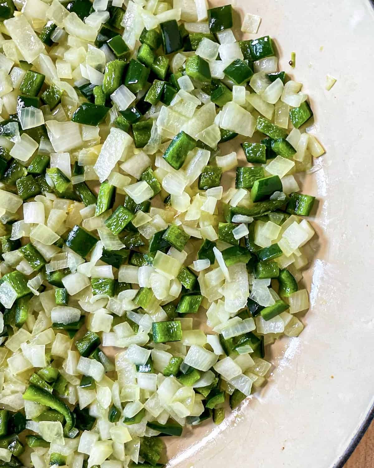 Diced yellow onion and poblano peppers that have been sautéd until translucent in a skillet.