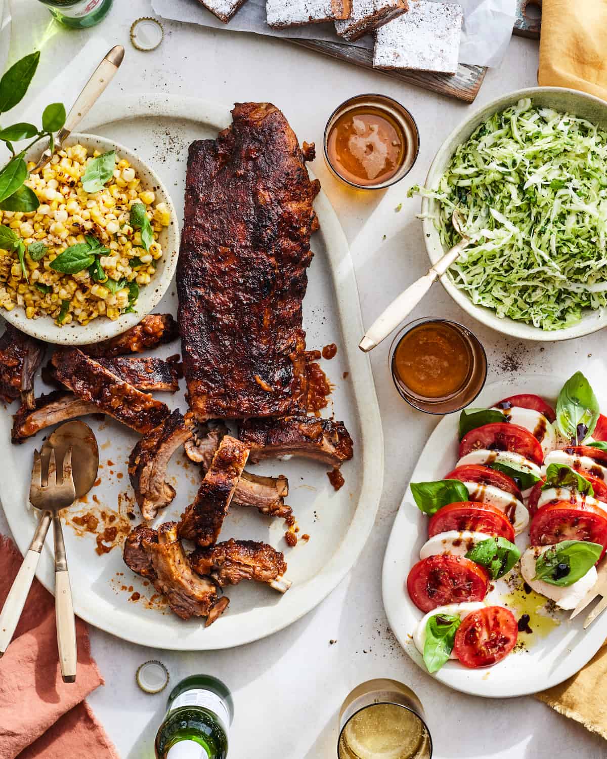 A dinner party spread with BBQ Baby Back Ribs, BBQ Corn Salad, an easy Slaw Salad and Caprese!