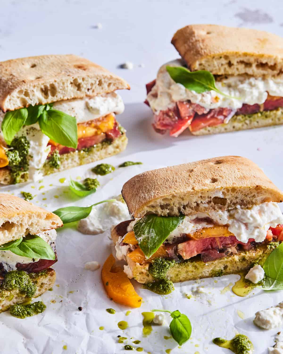 Burrata Caprese Sandwich with toasted bread, large chunks of burrata, fresh summer tomatoes and a LOT of pesto