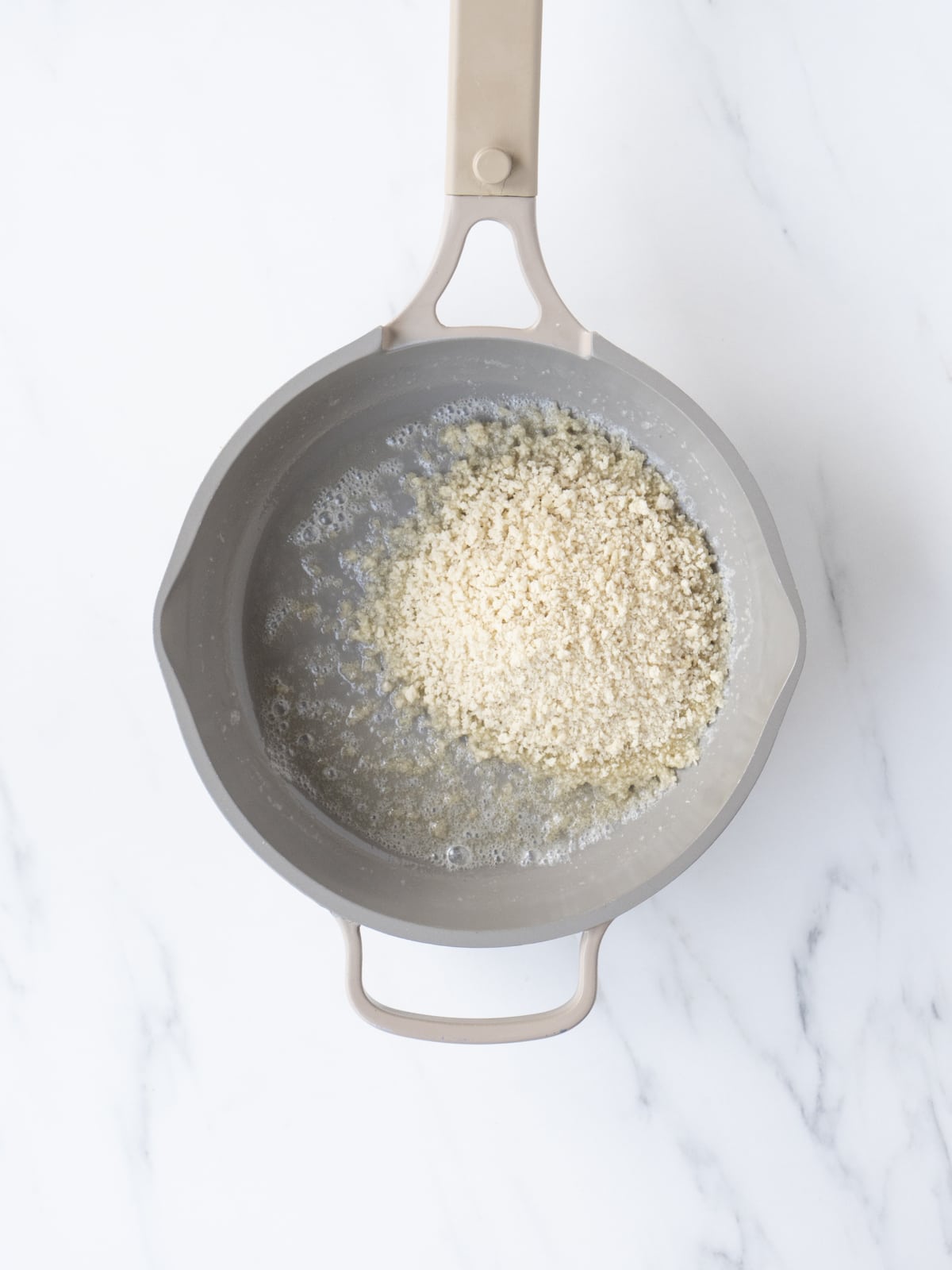 A small saucepan with butter and panko breadcrumbs.