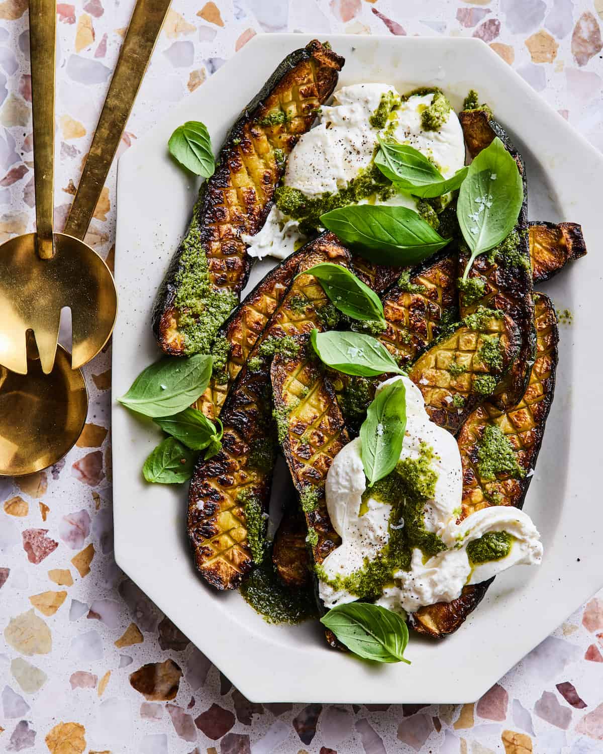 Thomas Keller's Zucchini with Burrata and Pesto on a platter with serving spoons