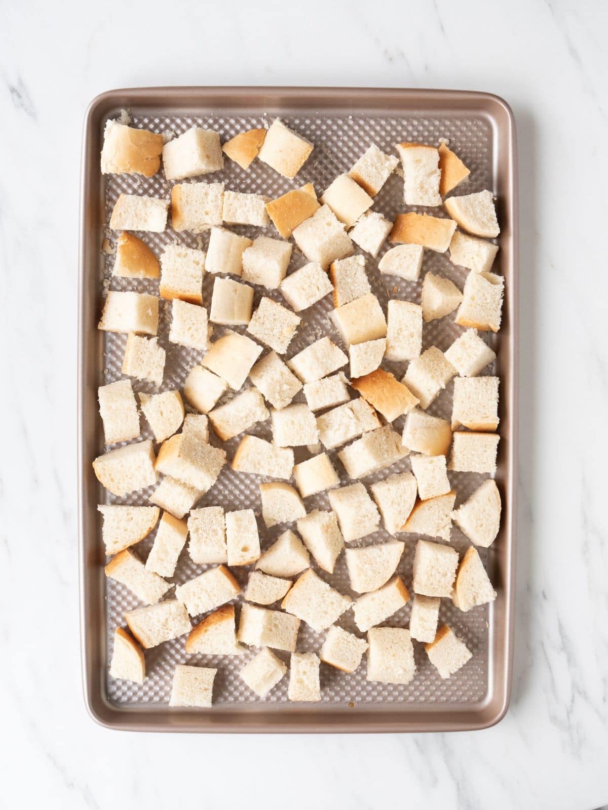 A baking sheet with cubes of bread.