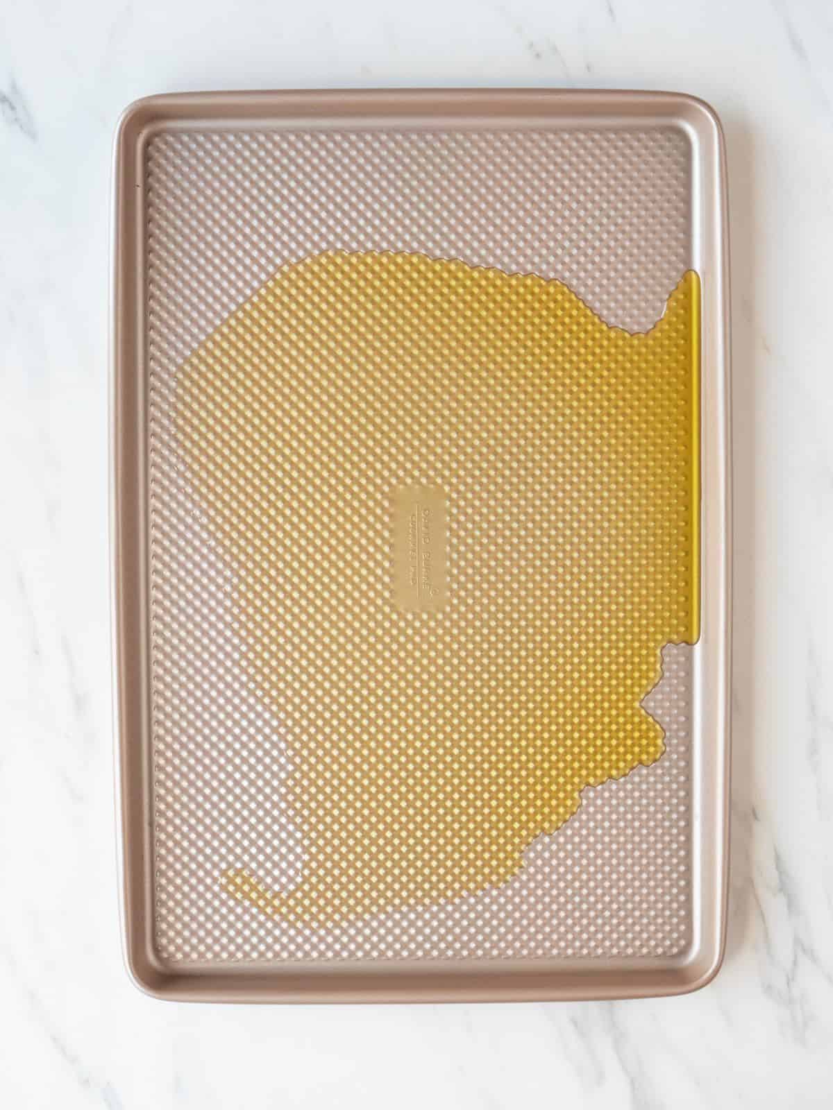 A baking sheet with hot oil on it.