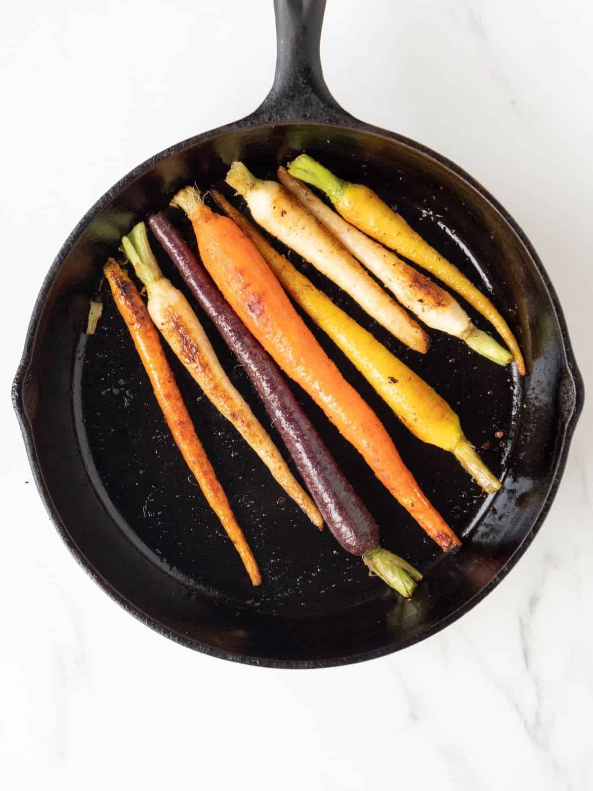 A skillet with rainbow carrots whole.
