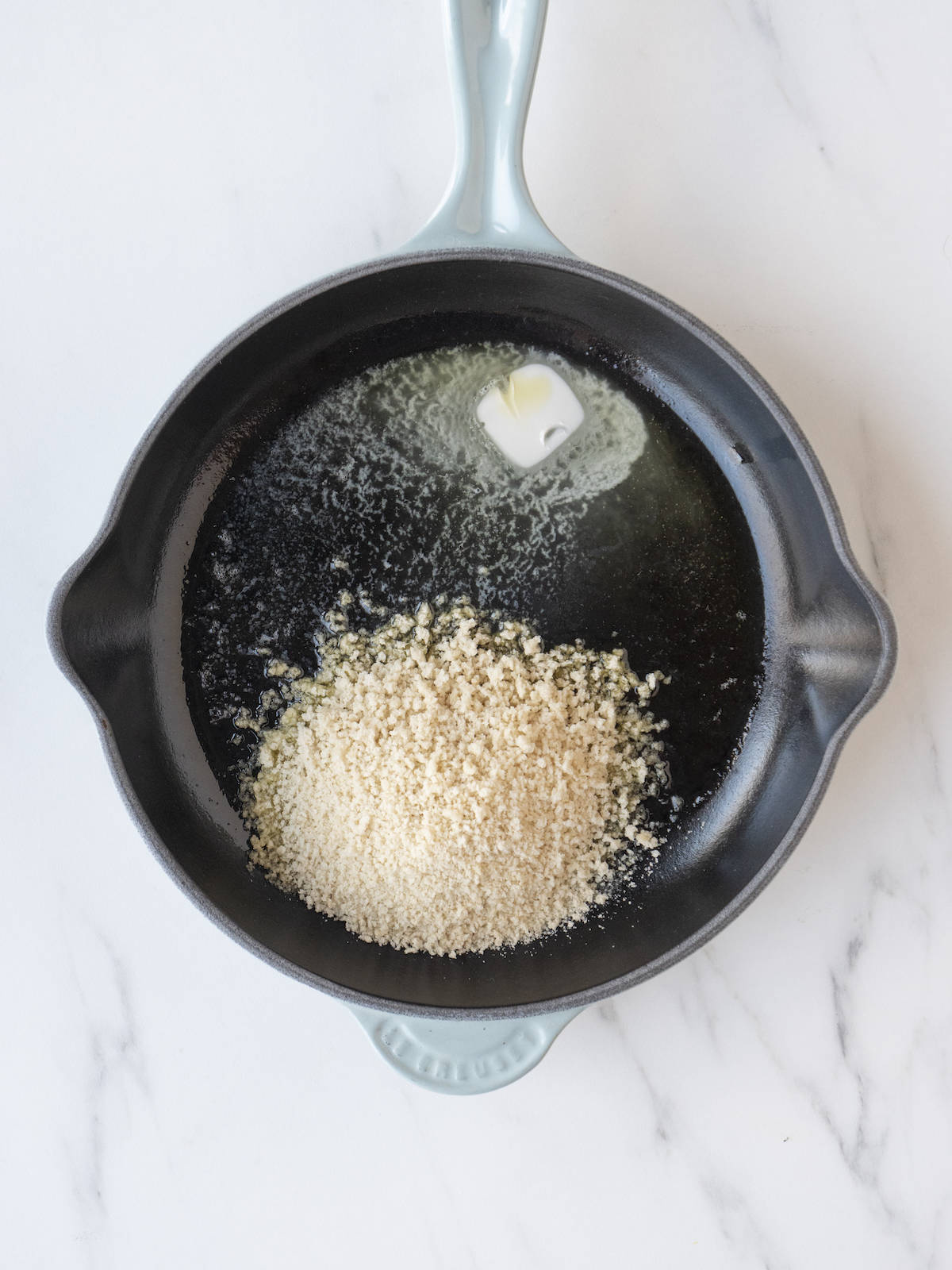 A skillet with olive oil, butter and panko bread crumbs in order to toast them.