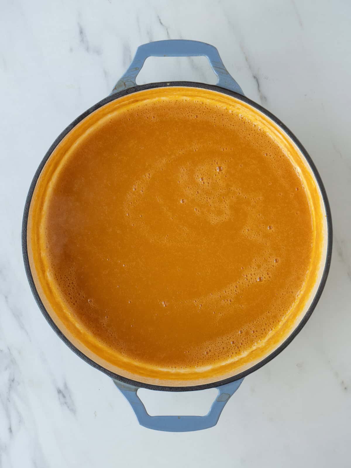 A pot with butternut squash and stock pureed into a smooth consistency.