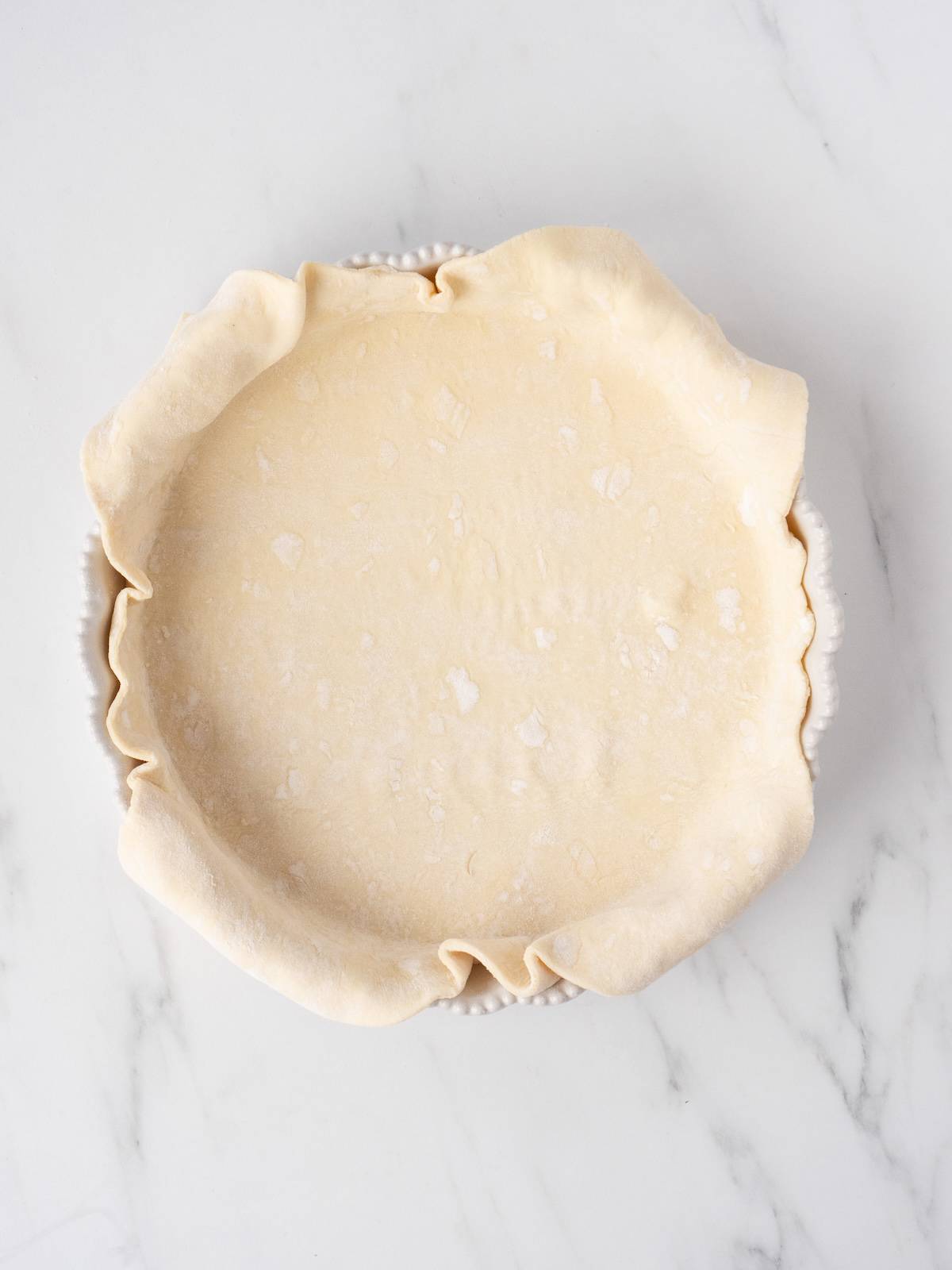 Puff pastry rolled out on a 9-inch pie dish and pressed down.