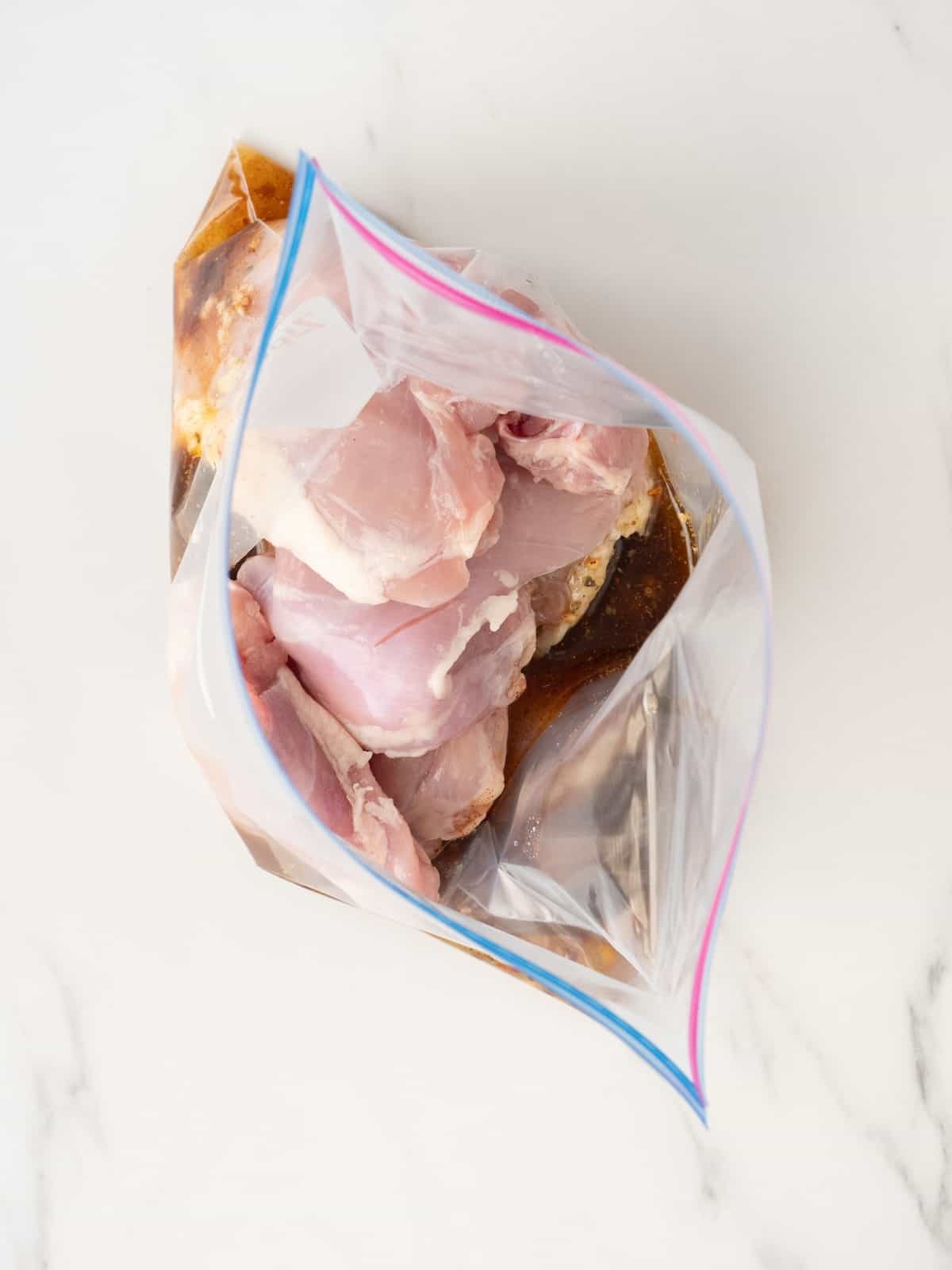 A large zip-top bag with all the seasonings and olive oil for the chicken marinade and chicken thighs.